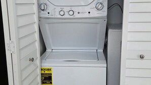 A compact washer and dryer unit with a control panel, a yellow price tag, and a door with a handle. - Peaceful accomodation. Walking distant to Port Richey waterfront restaurants. (Port Richey)