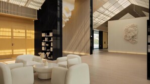 Un interior moderno con una zona de estar, estanterías y una escultura de pared original.