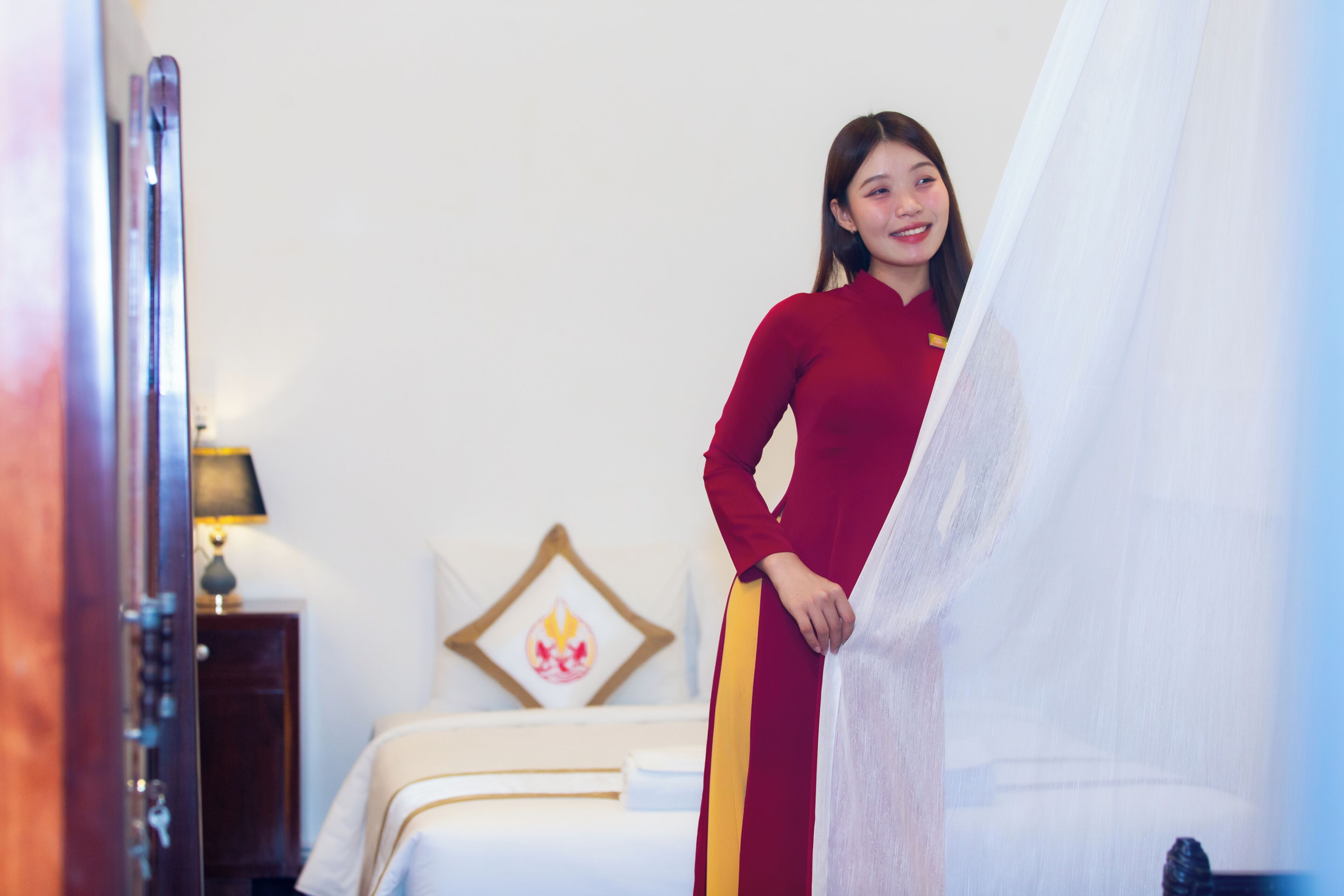 Een hotelkamer met een bed, nachtkastje en een decoratie aan de muur.