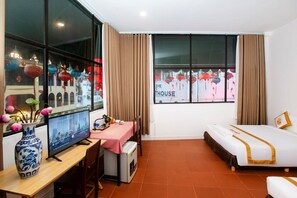 A hotel room with a bed, a desk with a computer, a small table, a TV, and a window with curtains. - The Rice Hotel & Tour - 195 De Tham (Ho Chi Minh City)
