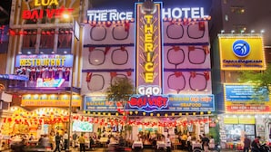 Eine belebte Straße mit mehreren Restaurants und einem Hotel.