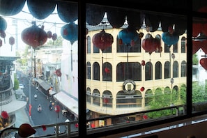 A building with a sign reading 'PASTEUR STREET CO.' and a view of a street with vehicles and hanging decorations.