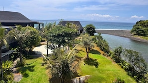 Een resort met uitzicht op de oceaan, palmbomen en een strand.