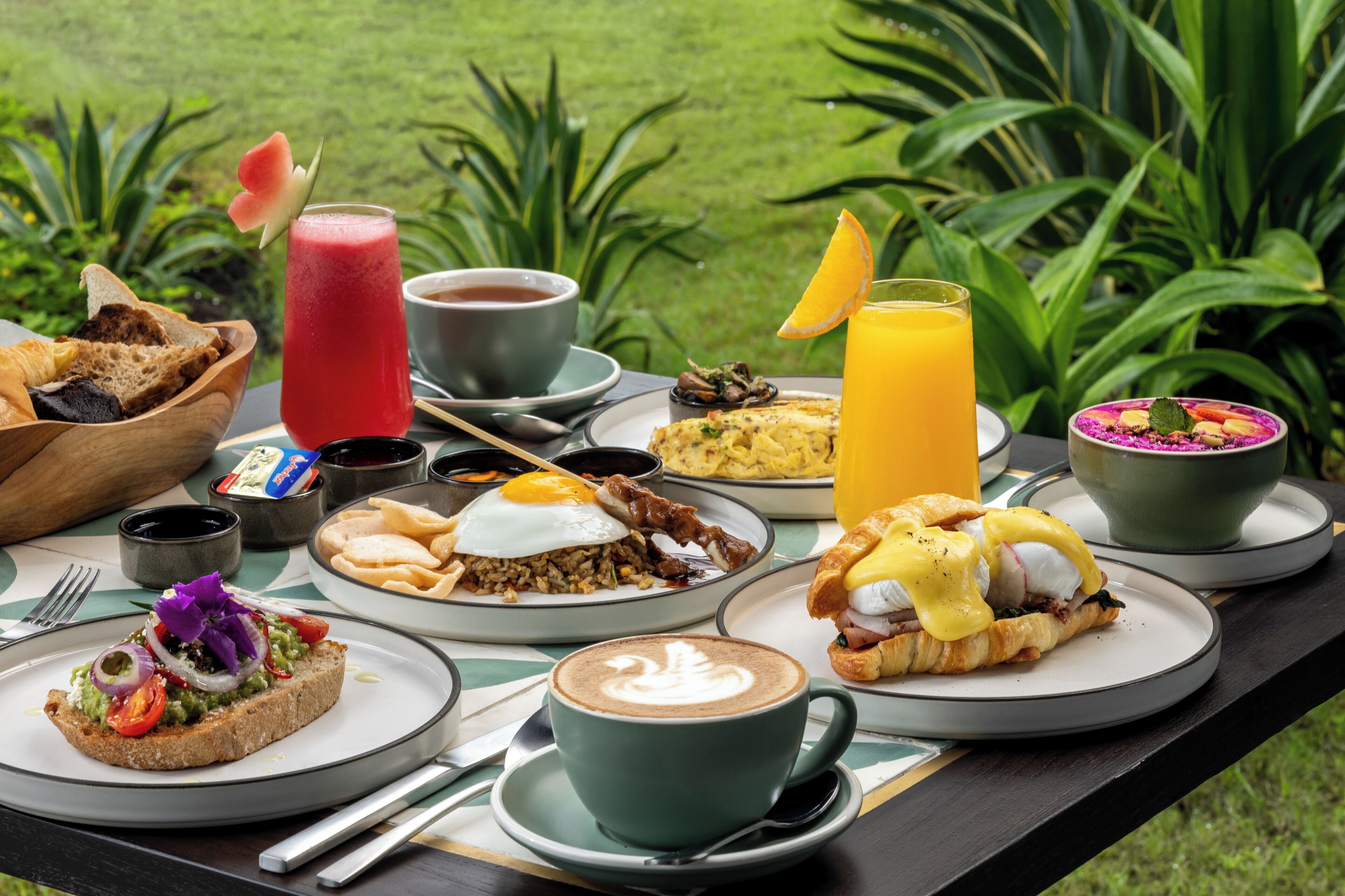 Una mesa de desayuno con diferentes platos, bebidas y una taza de café.