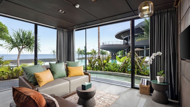 Ein modernes Wohnzimmer mit einer Couch, einem Couchtisch und Meerblick.