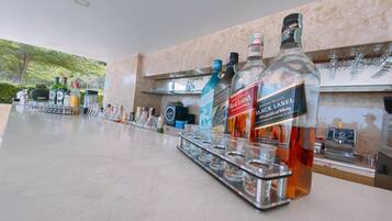 A bar area with multiple bottles of Johnnie Walker Red Label and Black Label whisky, glasses, and a music player.