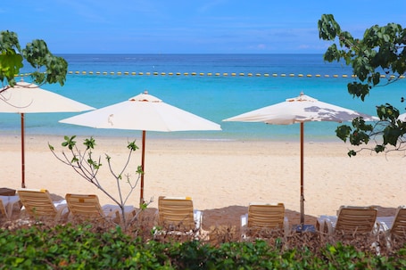 On the beach, white sand, sun loungers, beach umbrellas