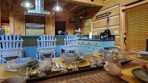A wooden cabin interior with a dining area, kitchen, and bar. - Harrah`s Casino & Sequoyah National - 6 minutes (Whittier)