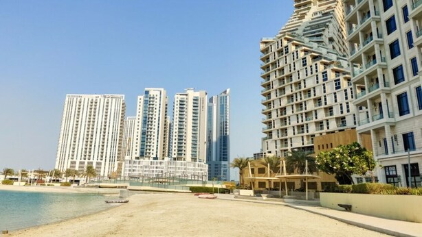 A beachfront hotel with high-rise buildings in the background, a sandy beach, and a clear sky. - Luxury Studio at Hydra C6 | Views & Prime Access (Abu Dhabi)