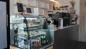 A bakery display case with various pastries and a selection of bottled beverages. - Chiang Mai Midpoint Activitiy Hostel  (Chiang Mai)