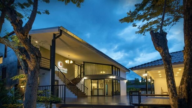 A modern building with a staircase leading to a covered entrance, surrounded by trees. - Chiang Mai Midpoint Activitiy Hostel  (Chiang Mai)