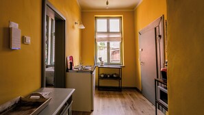 A compact kitchen with a window, a sink, and a small countertop. - Spend the night in a monument with a view of the trees in the middle of the old town (Halberstadt)