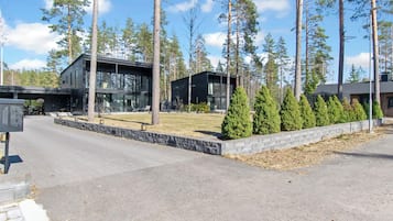 Un edificio moderno con entrada pavimentada y césped cuidado.