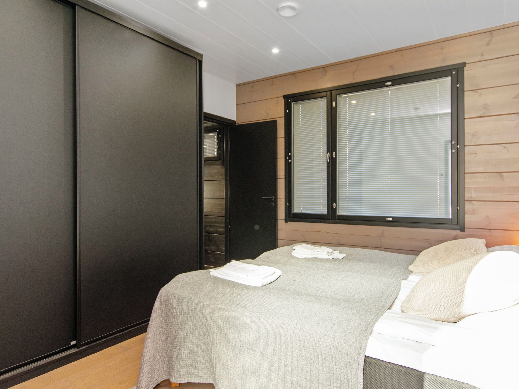 A bedroom with a bed, a wardrobe, and a window.