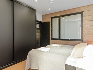 A bedroom with a bed, a wardrobe, and a window.