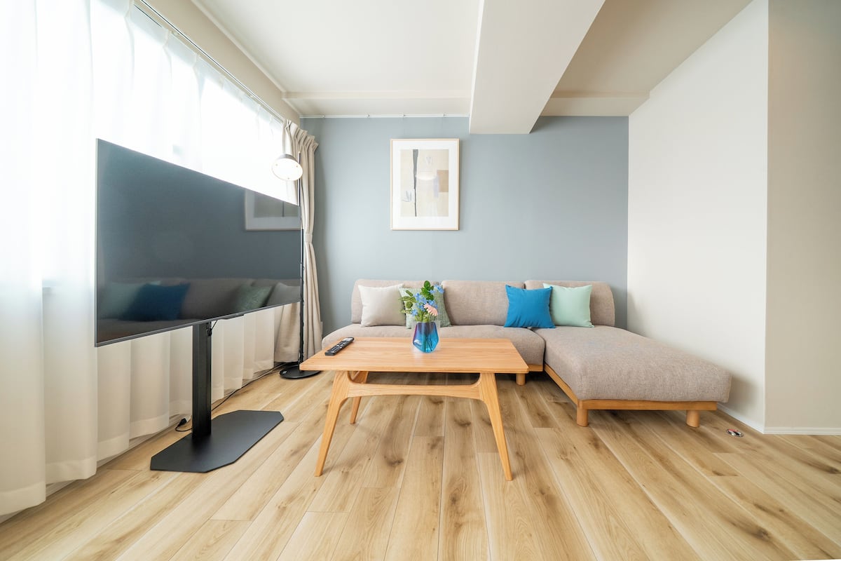 Un salon moderne avec un canapé, une table basse et un téléviseur.