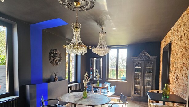 Une pièce spacieuse avec une grande table ronde, un canapé en cuir et un coin repas avec des chaises.