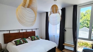 Une chambre moderne avec un grand lit, un plancher en bois et un tapis en peau de vache.