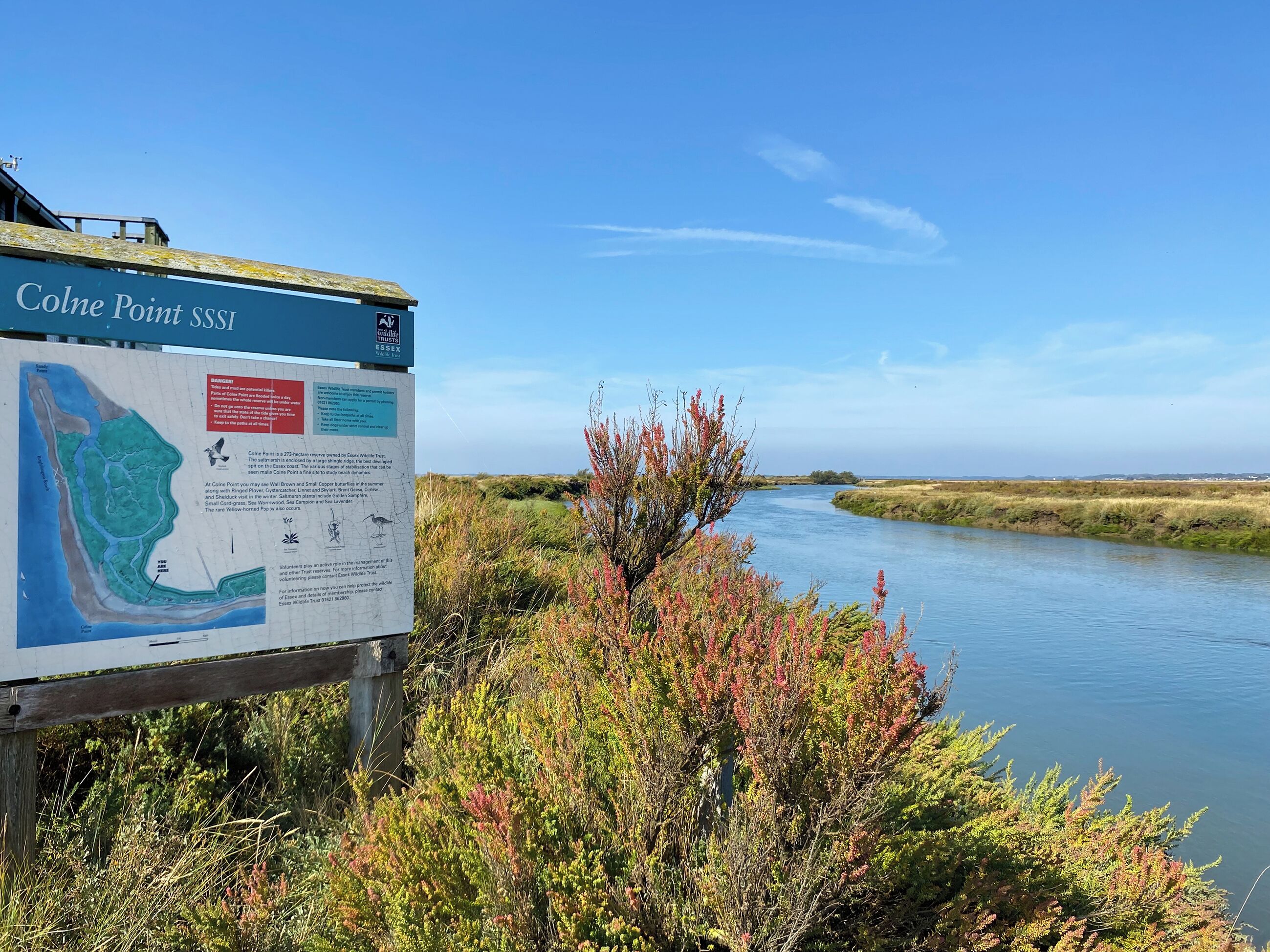 Un panneau d’information sur le site d’intérêt scientifique spécial de Colne Point, la rivière et la végétation environnante.