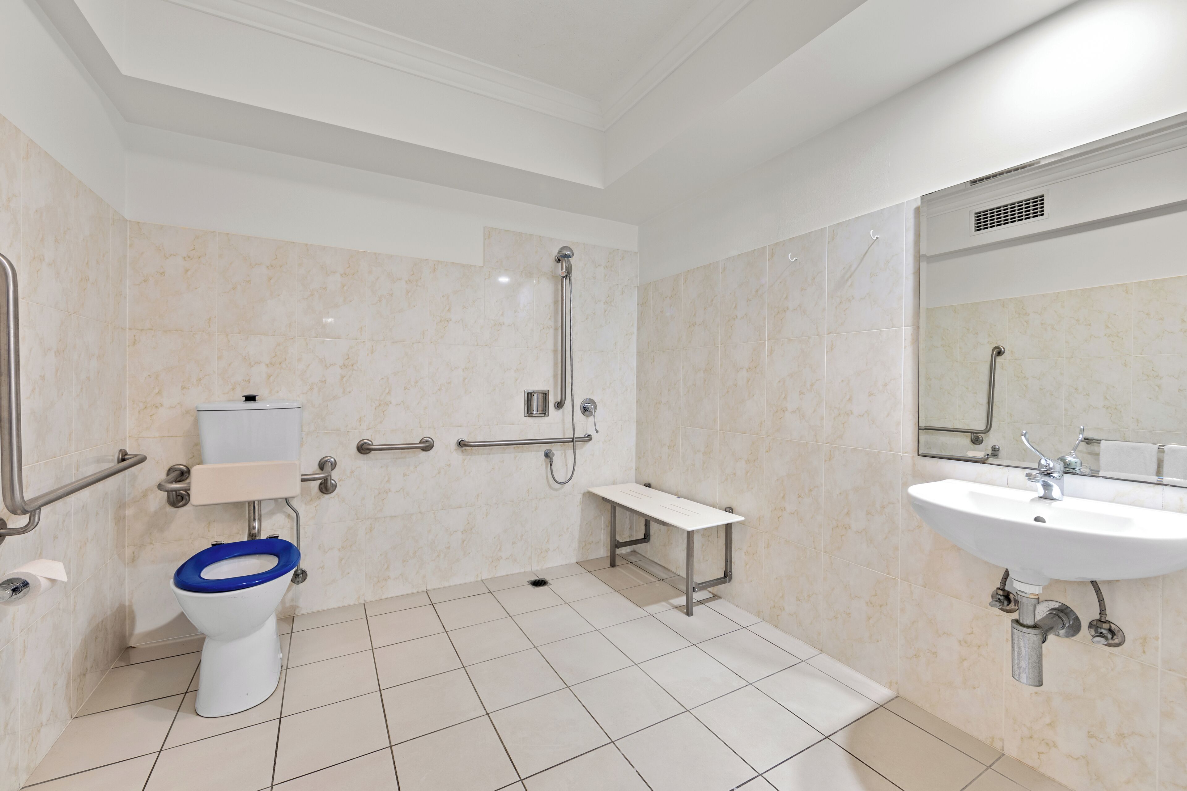 A modern bathroom with a toilet, shower, and sink.