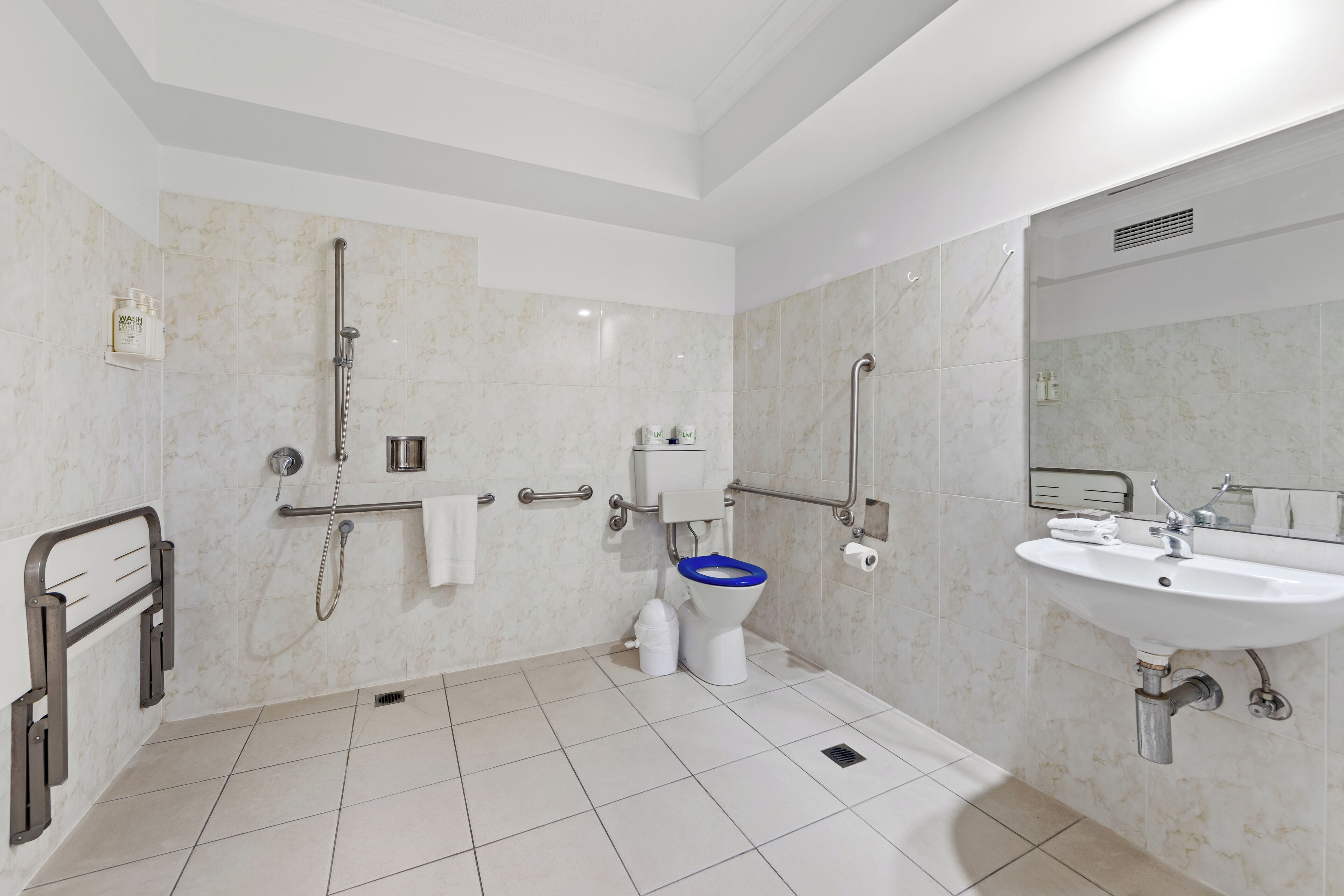 A modern bathroom with a shower, toilet, and sink.