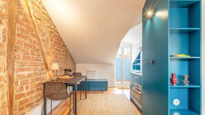 Een gezellige keuken met een bakstenen muur, houten vloer en een blauwe kast met planken.