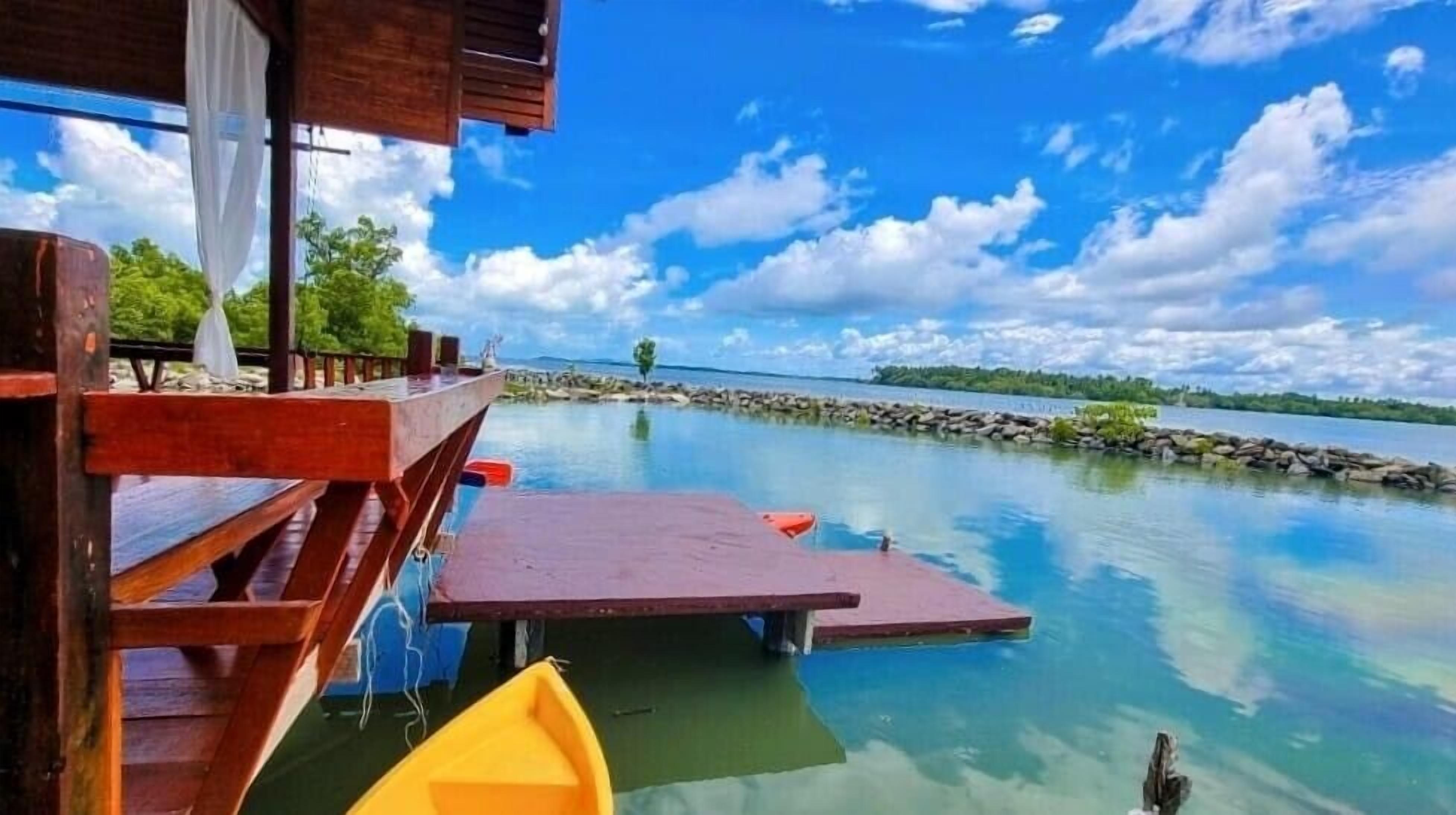 A wooden dock extending into a calm lake with clear skies.