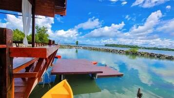 A wooden dock extending into a calm lake with clear skies.