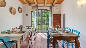 Un comedor con techo de madera, ventanas amplias y vista a zonas verdes.