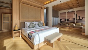Quarto moderno com uma cama grande, um banco, uma mesa de cabeceira e um ar condicionado fixado na parede.