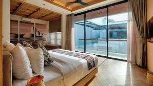 Quarto moderno com cama grande, teto de madeira e varanda com porta de vidro.