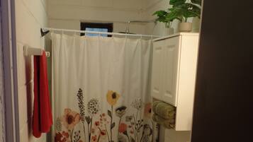 A small bathroom with a toilet, a sink, and a shower curtain with a floral pattern.