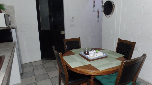 A dining area with a round table, four chairs, a green tablecloth, and a small decorative item on the table. - 🤑😎❤️ SE FACTURA❤️😎🤑 ARE YOU TRAVELING ON BUSINESS?? (San José del Cabo)
