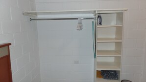 A white brick wall with a white shelf unit containing a towel rack, a folded towel, and a small shelf with a bottle. - 🤑😎❤️ SE FACTURA❤️😎🤑 ARE YOU TRAVELING ON BUSINESS?? (San José del Cabo)