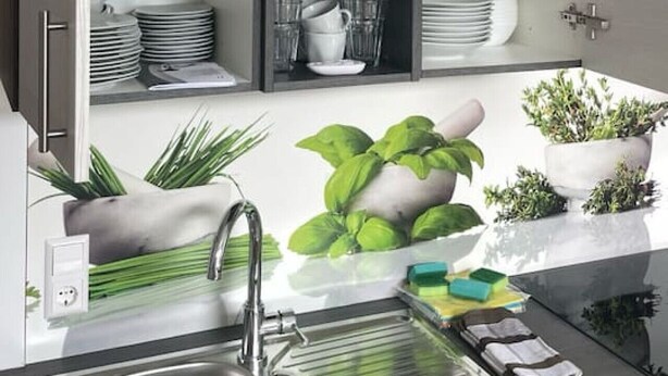 Una cocina moderna con un lavamanos integrado, un colador y una variedad de platos y vasos.