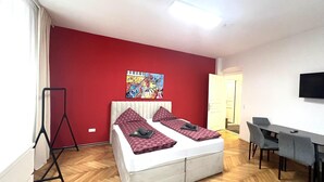 A room with a bed, a desk, a chair, a TV, and a poster on the wall. - Apartment Graz Eggenberg Top 8 (Graz)