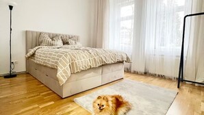 Ein Schlafzimmer mit einem Bett, einem Hund und einer Stehlampe.