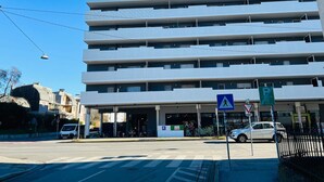 A multi-story building with a flat facade, a pedestrian crossing sign, and a parking sign. - 123 Apartment Graz - top 1 (Graz)