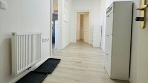 A narrow hallway with a radiator, a black mat, and a refrigerator. - Perfect for large travel groups! Leoben! (Leitendorf)