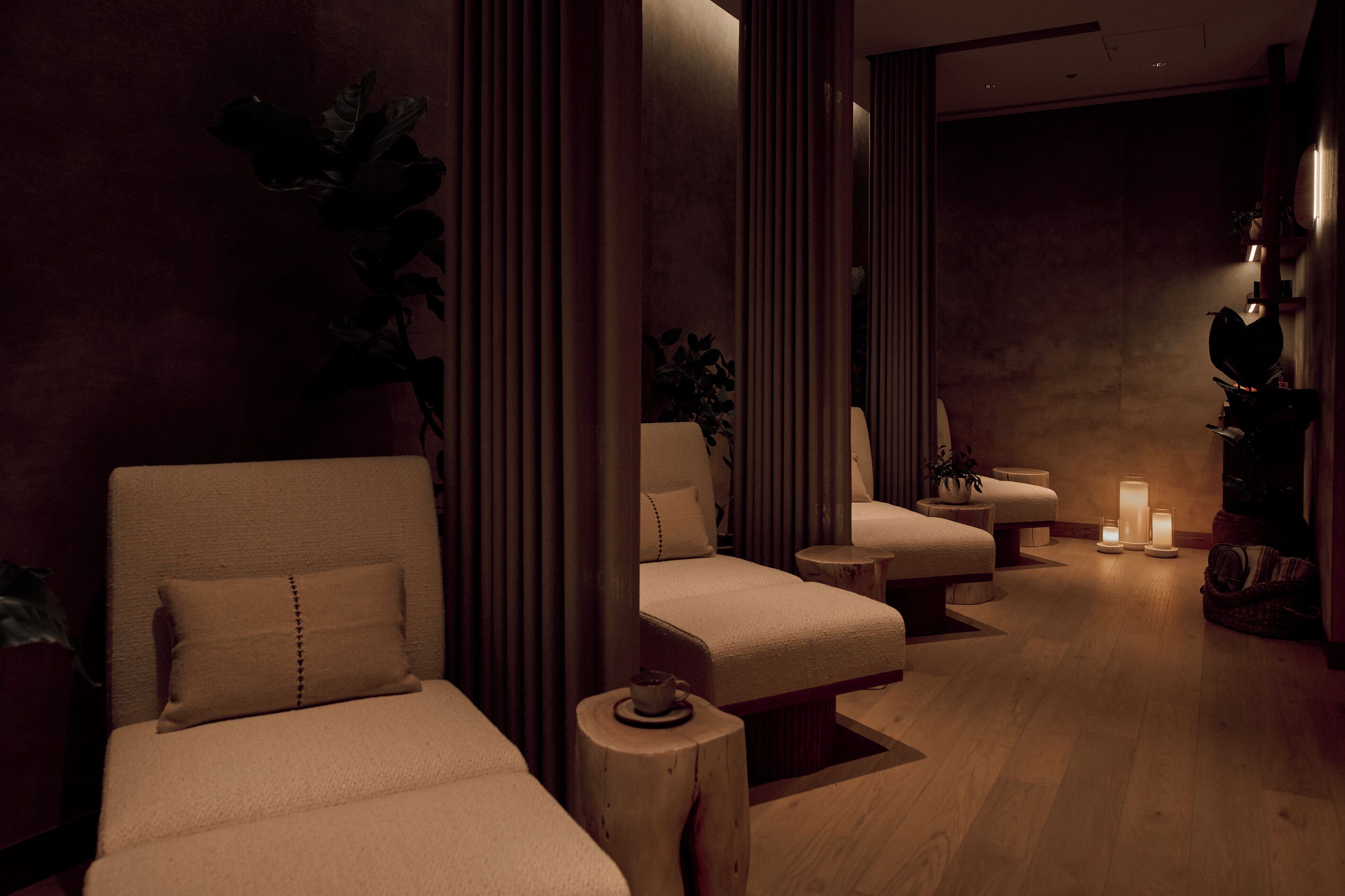 A spa room with two sofas, a small table, and a candle.