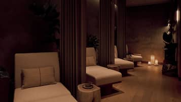 A spa room with two sofas, a small table, and a candle.