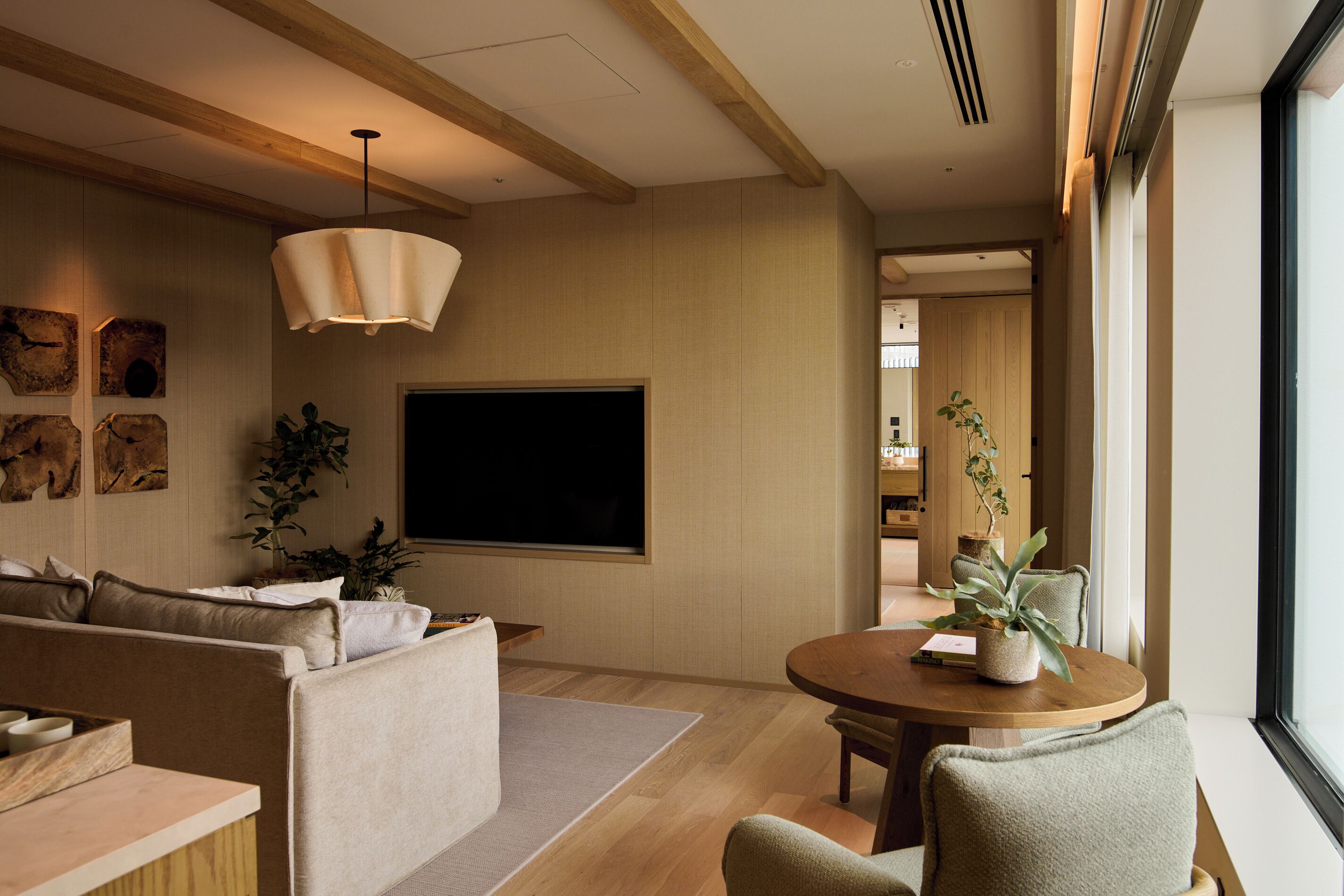 Una sala de estar moderna con un sofá, un televisor de pantalla plana y una mesa de comedor con sillas.