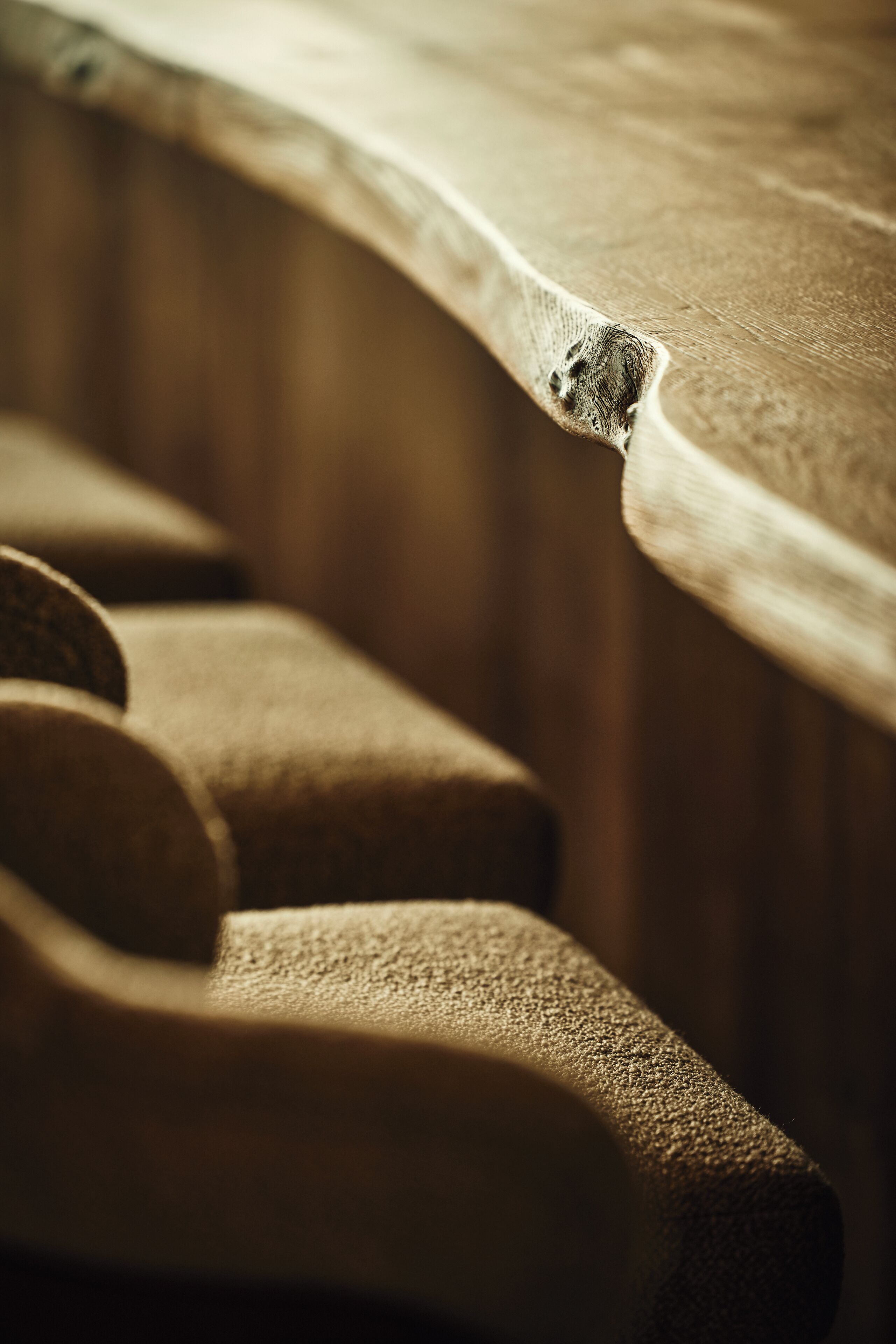 A close-up of a wooden surface with a visible knot and a worn edge.
