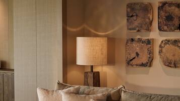 A cozy corner with a sectional sofa, a lamp, and rustic wall art.