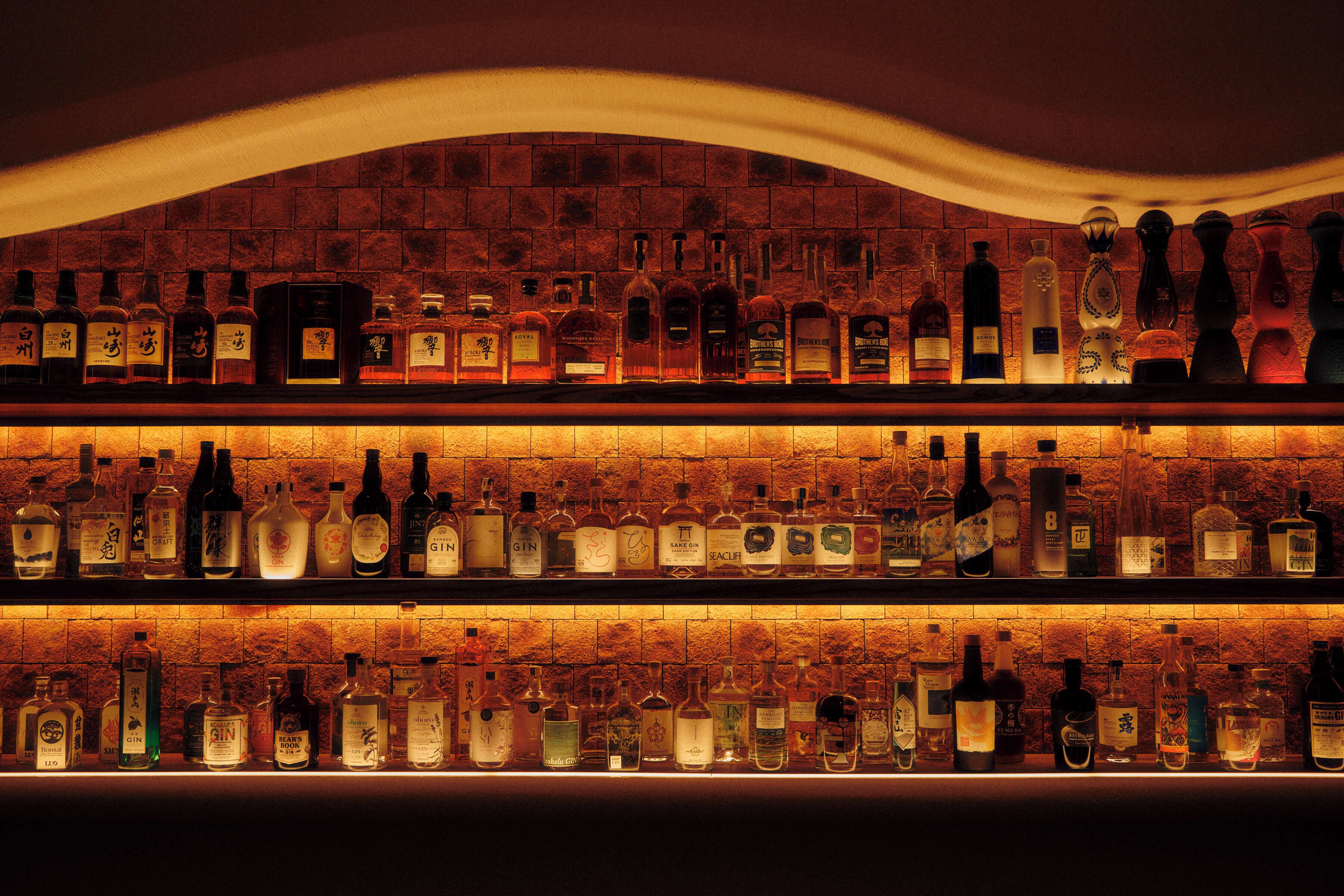 A bar with multiple shelves of liquor bottles.