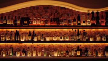 A bar with multiple shelves of liquor bottles.
