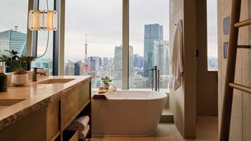 Un bagno moderno con vasca, ampie finestre e vista sulla città.