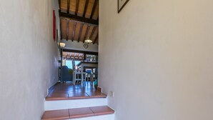 Eine Treppe mit Terrakotta-Stufen führt zu einem Essbereich mit Tisch und Stühlen.