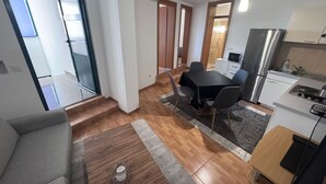 A modern apartment with a dining area, kitchen, and a living space with a sofa and a coffee table. - Apartment Centar (Ploce)