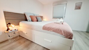 Un dormitorio moderno con cama, mesita de noche, lámpara y ventana con persianas.